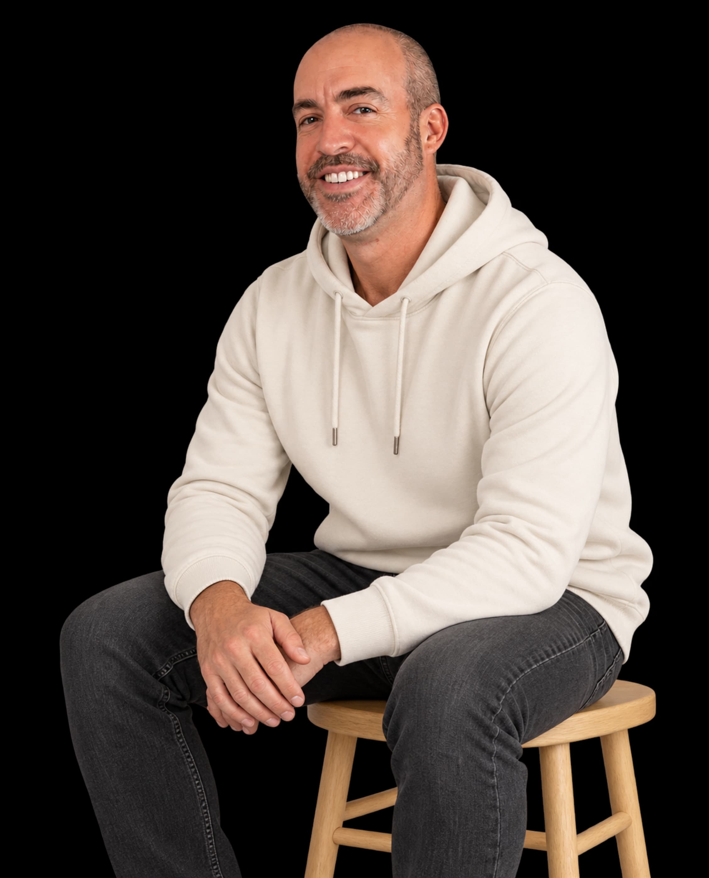 Adam Godsall in a Bone hoodie, sitting relaxed on a wooden stool